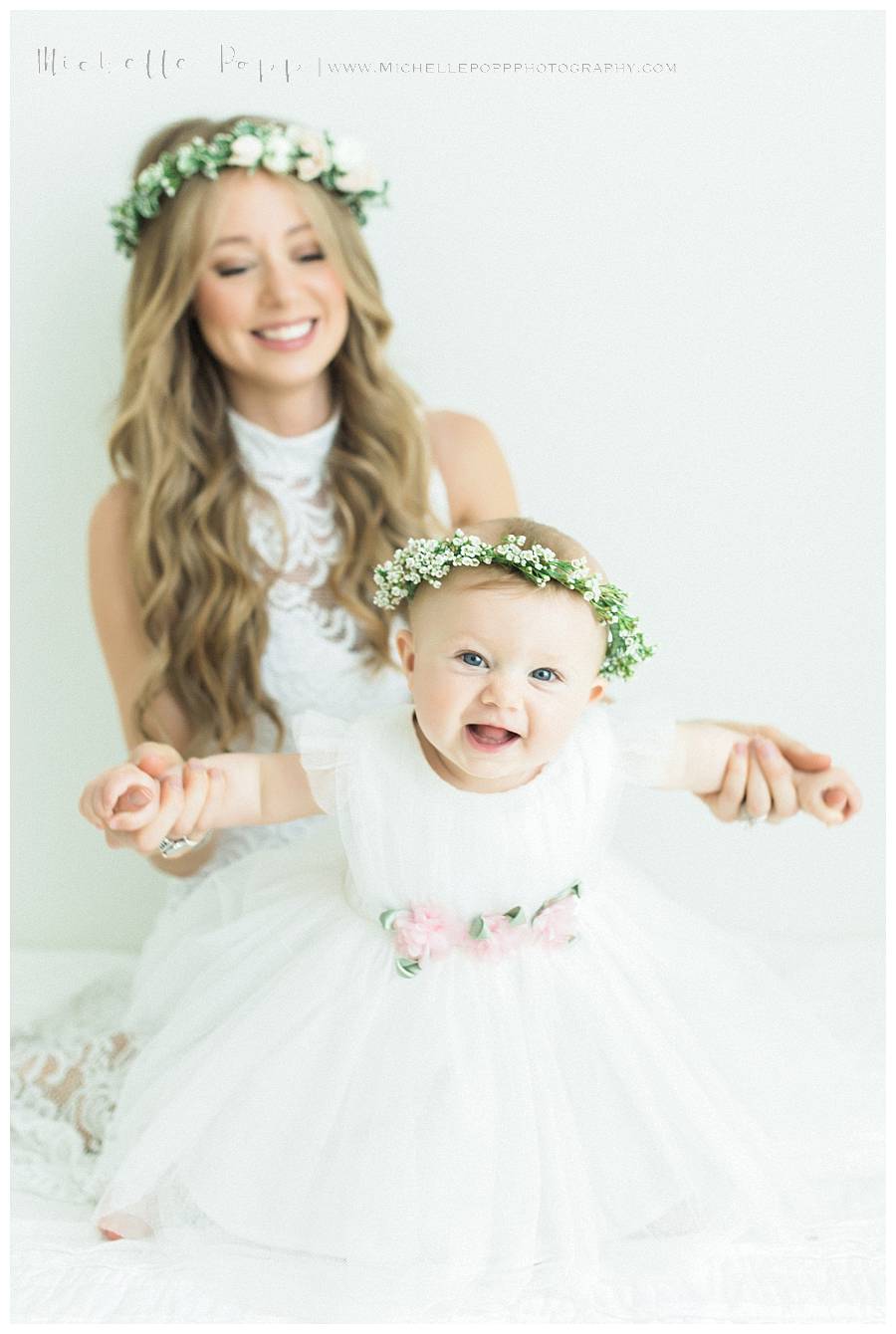 daughter sitting on moms lap in flower crown