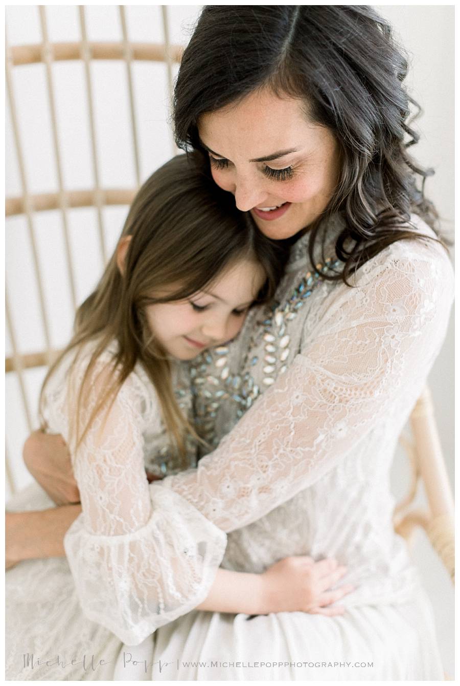 mom holding little girl in arms and smiling
