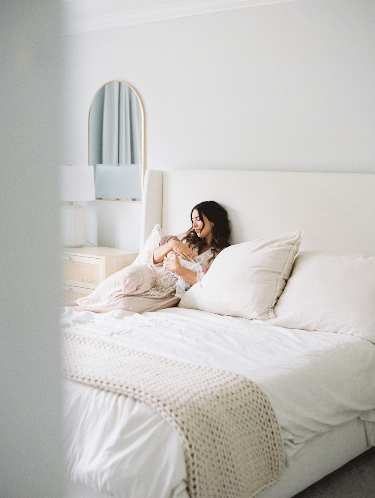 mom laying on bed with newborn baby in Wilmington